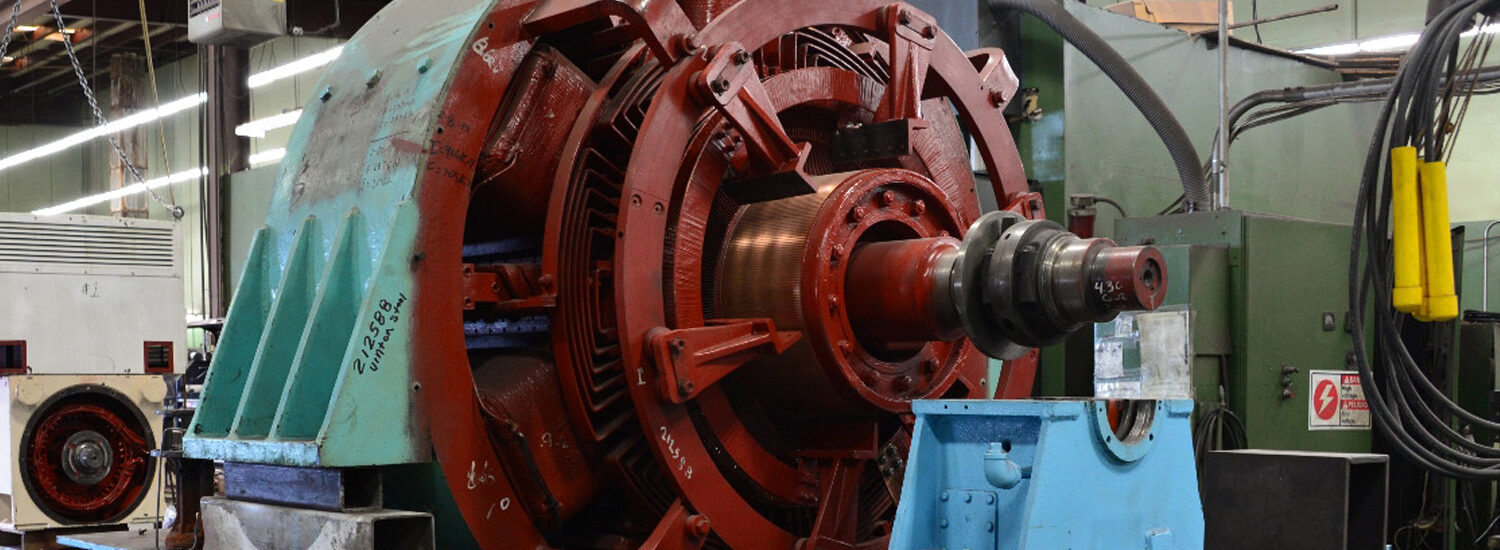 Close-up view of a large industrial electric motor undergoing repair and refurbishment inside a motor repair facility, showcasing precision engineering and heavy-duty components.