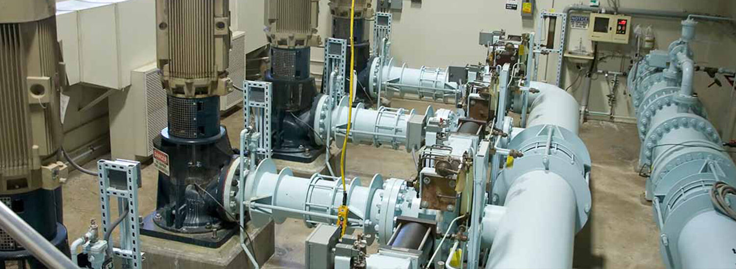 Industrial pump room featuring high-capacity centrifugal pumps and electric motors, showcasing precision-engineered components for water treatment, wastewater management, and fluid transfer systems.